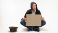 Young begging man with blank cardboard.
