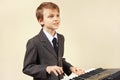 Young beginner musician in a suit playing electronic piano Royalty Free Stock Photo