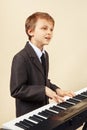 Young beginner musician in suit playing the electronic synthesizer Royalty Free Stock Photo