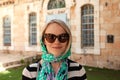 A young believing woman stands in a scarf near the entrance to a church in Jerusalem, Israel Royalty Free Stock Photo