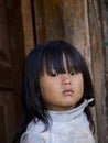 Young Bhutanese girl standing in front of her shed