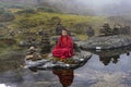 Young Bhutanese novice monk practices meditation in the centre of plateau lake , Bhutan.