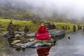 Young Bhutanese novice monk practices meditation in the centre of plateau lake , Bhutan.