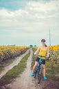 Young bicyclist riding in sunflower field