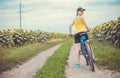 Young bicyclist riding in sunflower field