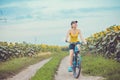 Young bicyclist riding in sunflower field