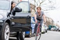 Young bicyclist shouting while swerving for avoiding dangerous collision