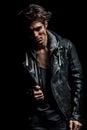 Young biker in leather jacket pulling his collar Royalty Free Stock Photo