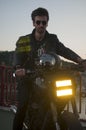 a young biker shines a headlight on his motorcycle Royalty Free Stock Photo