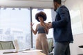 Young biracial colleagues discussing while planning strategy in boardroom during meeting Royalty Free Stock Photo