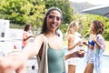 Young biracial woman in a green tank top taking a selfie at a pool party Royalty Free Stock Photo