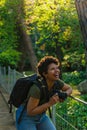 Young black African American female photojournalist with dark curly hair laughing happily looking at something wonderful to come