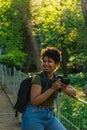 Young black African American female photojournalist with dark curly hair laughing happily looking at something wonderful to