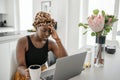 Young Black African business woman, hand on head, stressed looking at laptop Royalty Free Stock Photo