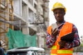 Young black African man construction worker holding clipboard an