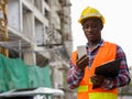 Young black African man construction worker holding clipboard wh