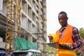 Young black African man construction worker reading on clipboard Royalty Free Stock Photo