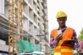 Young black African man construction worker reading on clipboard Royalty Free Stock Photo