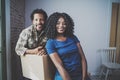 Young black african man and his girlfriend moving boxes into new house together and making a beautiful life.Cheerful
