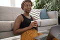 Young Black African woman, wearing traditional scarf, lounge at home Royalty Free Stock Photo