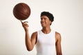 Young black athlete balancing leather basketball on finger