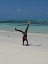 Young black boy doing handstand on white sand beach, Zanzibar,Tanzania Royalty Free Stock Photo