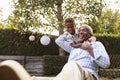 Young black boy embracing grandfather sitting in garden