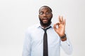 Young black businessman having happy look, smiling, gesturing, showing OK sign. African male showing OK-gesture with his Royalty Free Stock Photo