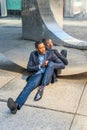 Young black man sitting  on ground against mirror outdoors in New York City, relaxing Royalty Free Stock Photo