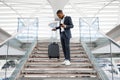 Young Black Businessman With Smartphone Walking Down Stairs At Airport Terminal Royalty Free Stock Photo