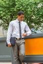 Young black businessman standing on street, looking down at his wristwatch Royalty Free Stock Photo