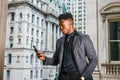 Young black businessman texting on cell phone outside office building in New York City Royalty Free Stock Photo