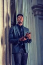 Young black businessman texting on cell phone outside office building in New York City Royalty Free Stock Photo