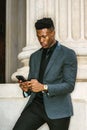 Young black businessman texting on cell phone outside office building in New York City Royalty Free Stock Photo