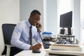 Young black businessman using the phone at his office desk Royalty Free Stock Photo