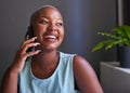 A young Black businesswoman laughs while on the phone in her office Royalty Free Stock Photo