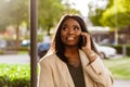 Young black businesswoman talking on cellphone while walking outdoors Royalty Free Stock Photo