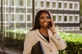 Young black businesswoman talking on cellphone while walking outdoors Royalty Free Stock Photo