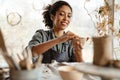 Young black ceramist woman sculpting in clay at her workshop