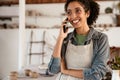 Young black ceramist woman talking on cellphone in her studio