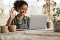 Young black ceramist woman using laptop while working in her studio