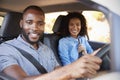 Young black couple in a car on a road trip smiling to camera Royalty Free Stock Photo