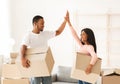 Young black couple with carton boxes high fiving each other in their rented property on moving day Royalty Free Stock Photo