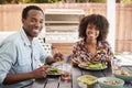 Young black couple eating in the garden looking to camera Royalty Free Stock Photo