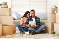 Young black couple using laptop computer and credit card for online shopping at their new home on moving day Royalty Free Stock Photo