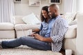 Young black couple using laptop sitting on the floor at home Royalty Free Stock Photo