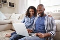 Young black couple using laptop sitting on the floor at home Royalty Free Stock Photo