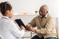 Young black doctor explaining treatment plan to male patient Royalty Free Stock Photo