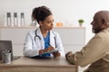 Young black doctor writing personal information, filling form Royalty Free Stock Photo