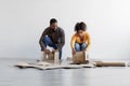 Young black family stack cardboard boxes and prepare to moving to new home. Renovation, relocating and buying new house Royalty Free Stock Photo